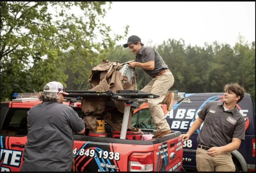 Absolute Best Air team members loading equipment onto a branded service truck