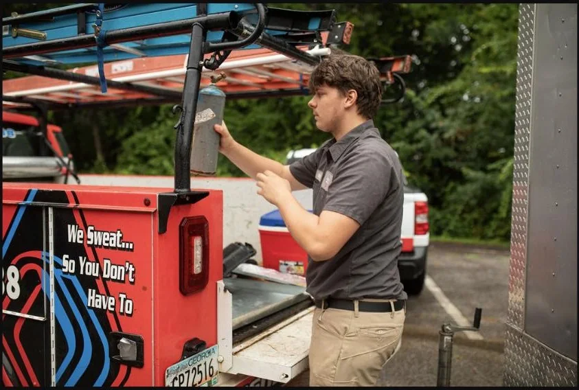 Absolute Best Air team member handling service tubing beside a branded truck