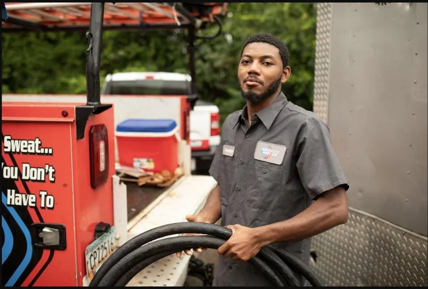 Absolute Best Air team member beside service equipment and a branded vehicle