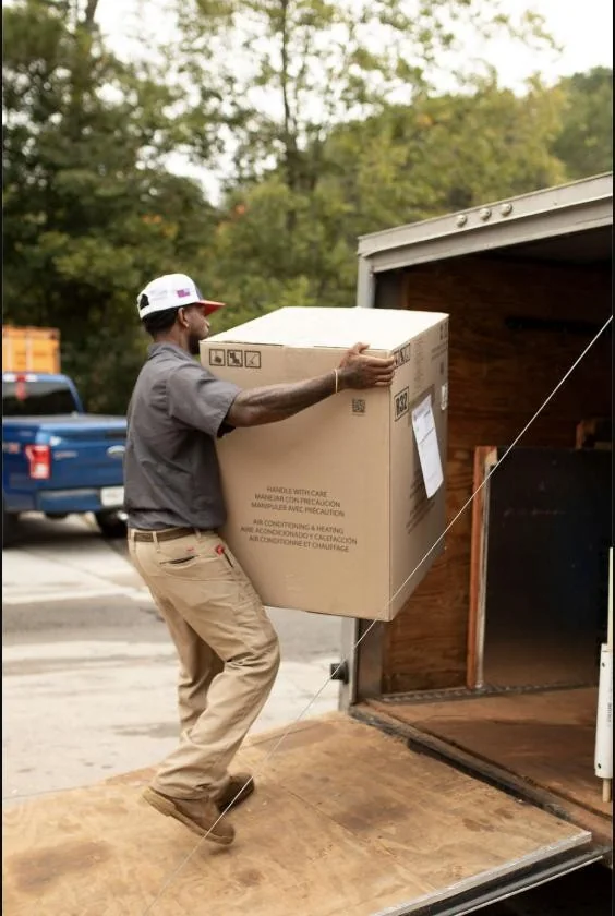 Absolute Best Air team member carrying boxed equipment into a trailer