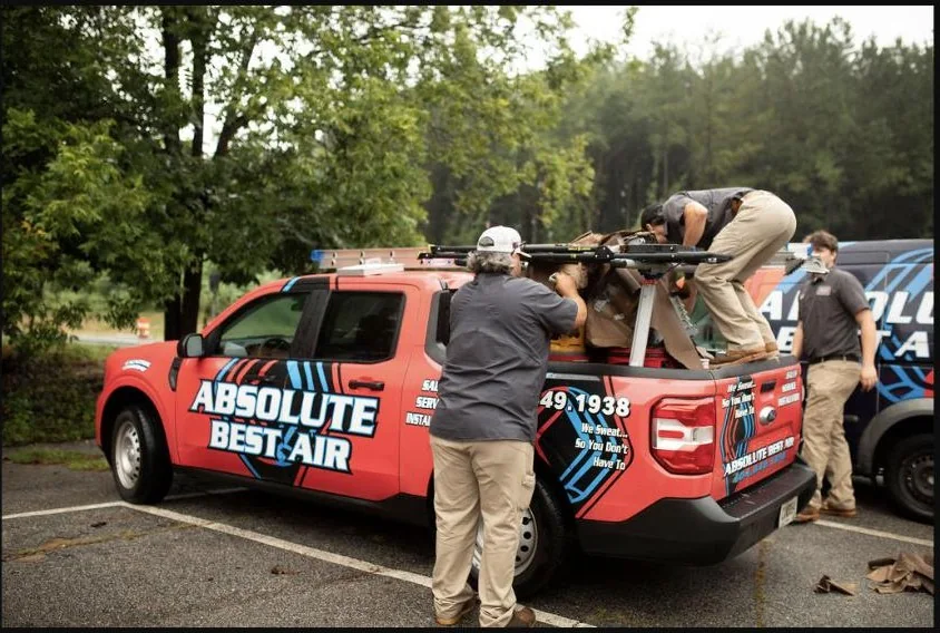 Absolute Best Air team member beside a branded service truck